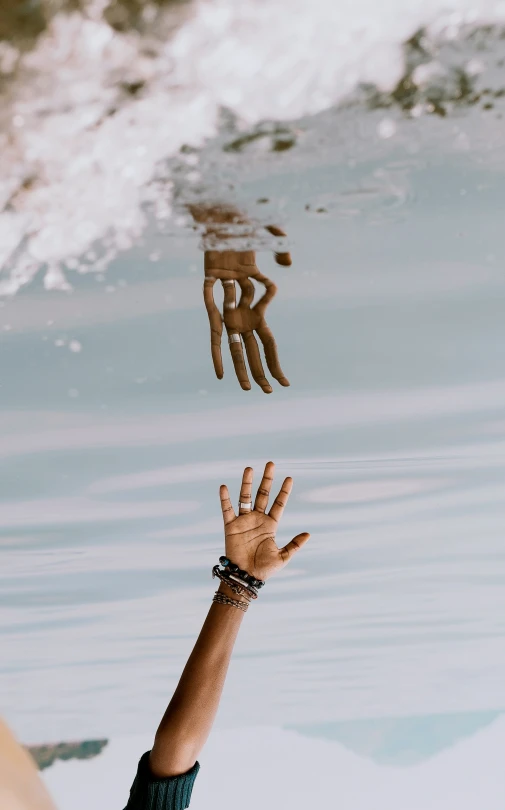 a hand reaches to reach soing from the water