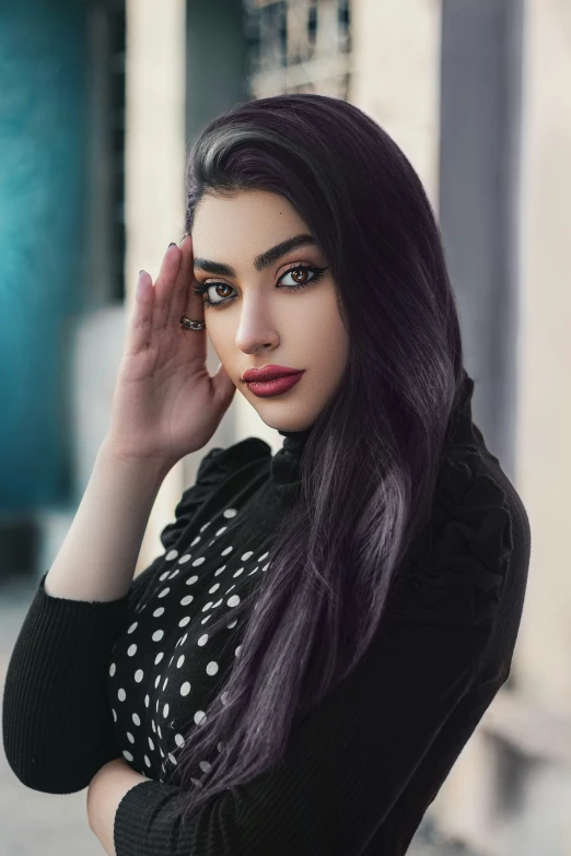 a girl with long black hair looks at the camera and poses in a black dress