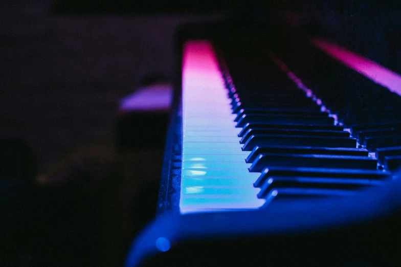 a piano is illuminated with brightly colored light