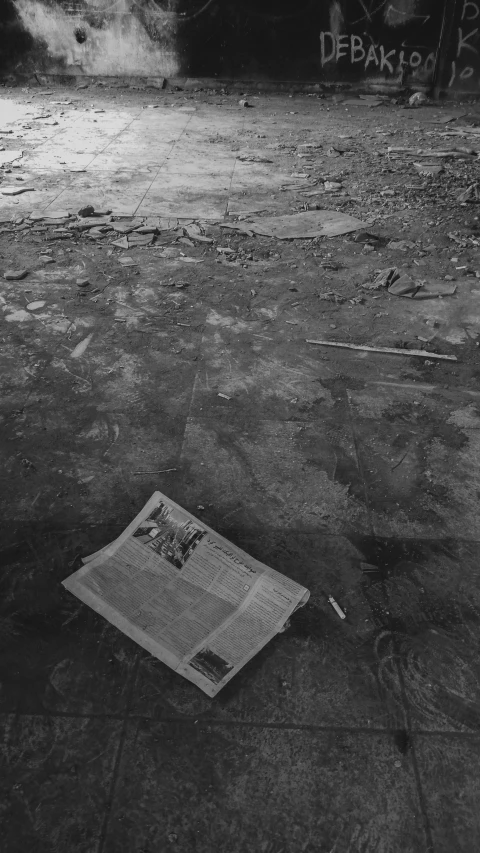 newspaper lying on the ground and graffiti near it