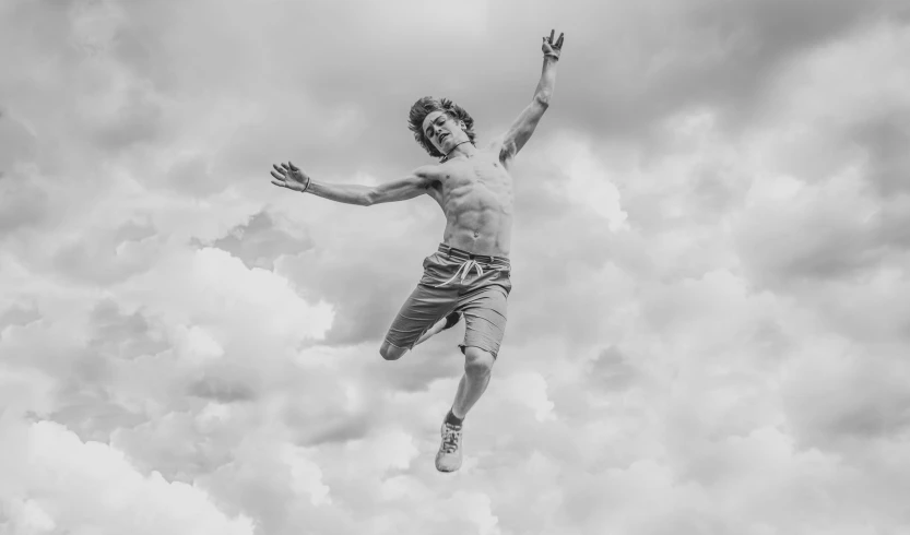 a man jumping up in the air against cloudy sky