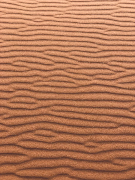 a sand dune with some ridges and waves in the sand