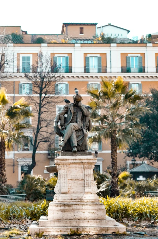 a statue in front of a large brown building