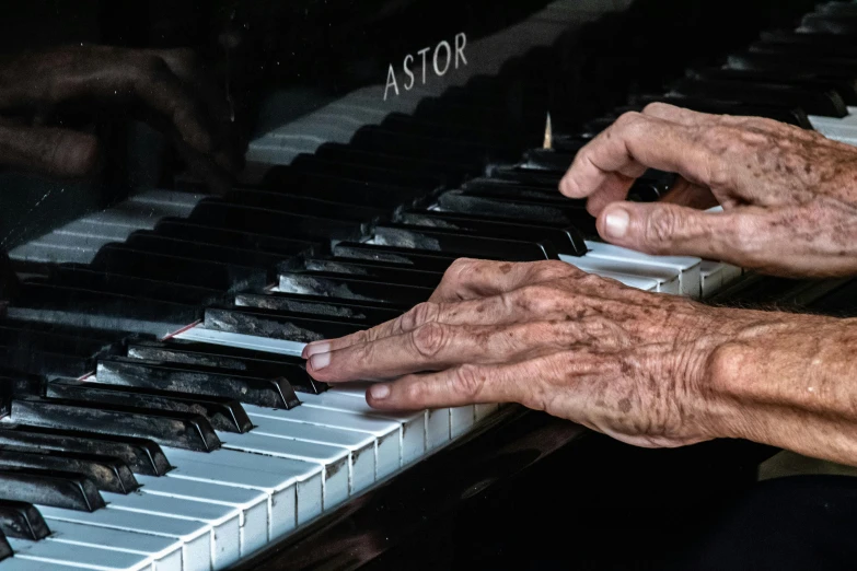 two hands on a piano that is touching it