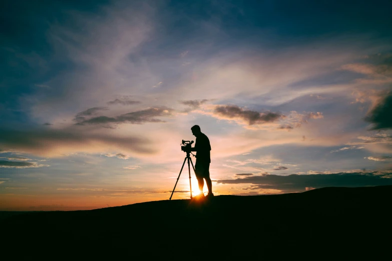 the pographer is taking pictures in the sunset