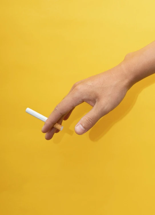 there is a hand that is holding a cigarette