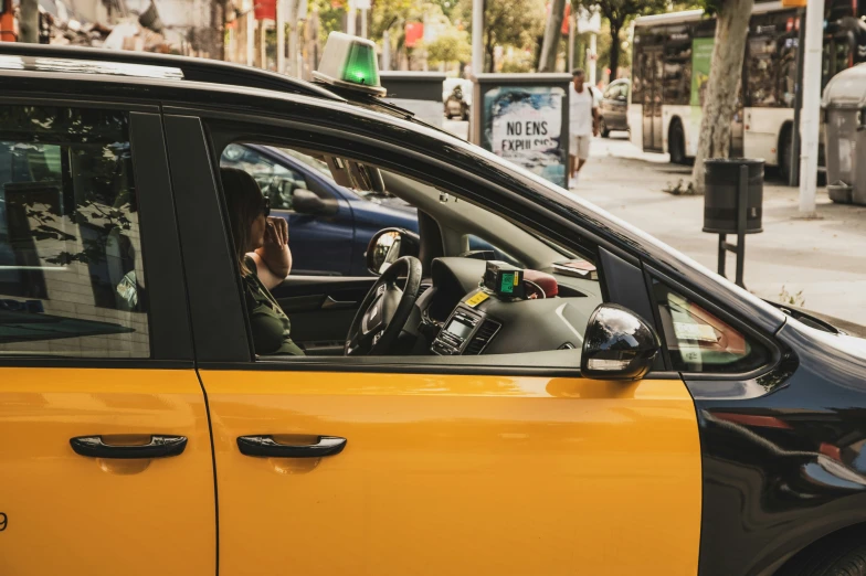 a taxi driver driving down the street in a taxi