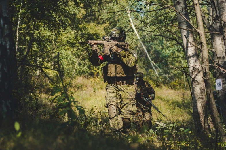 the man in camouflage is holding his rifle