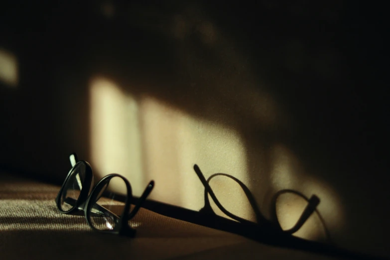 some reading glasses sitting against the wall near one another