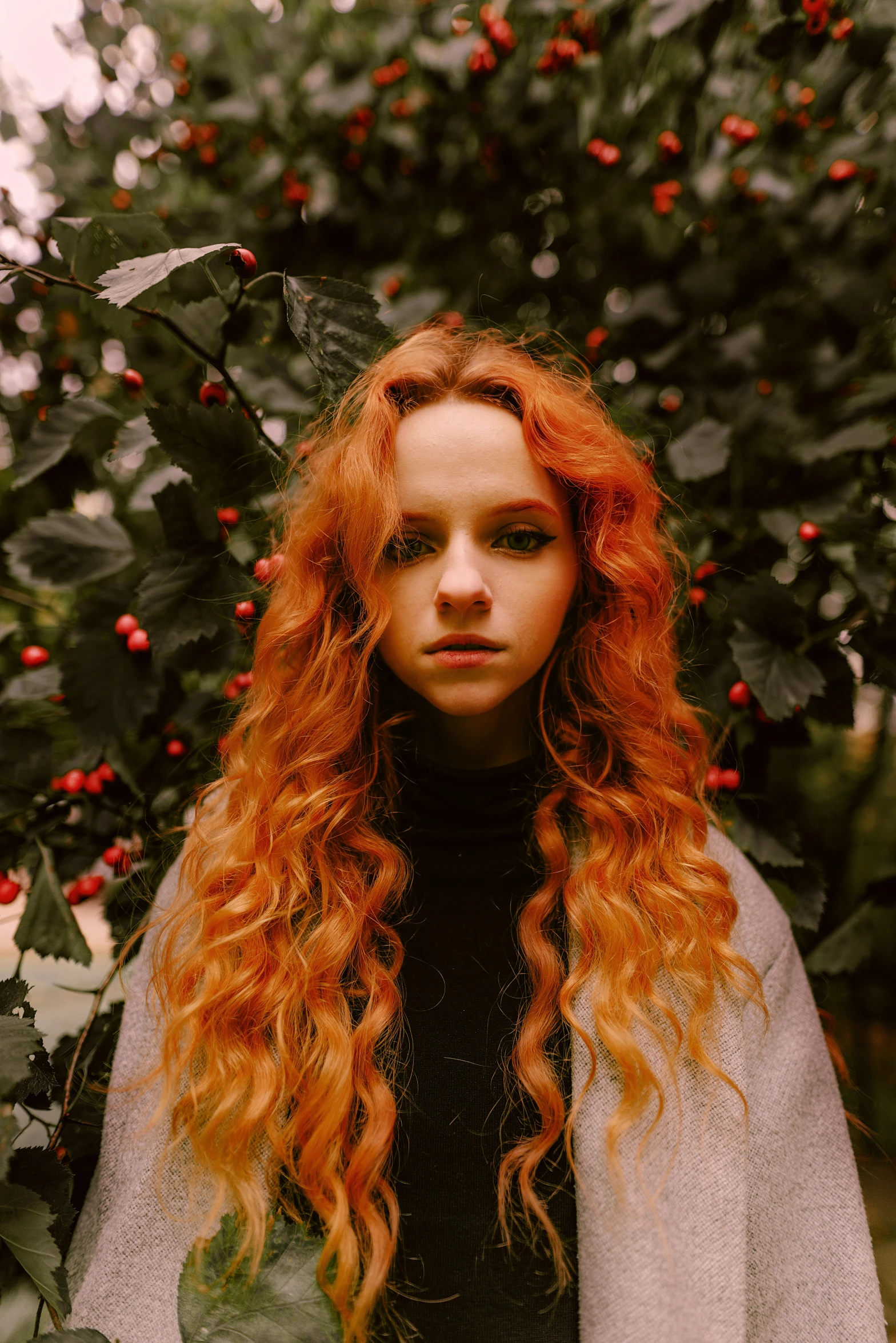 a woman with red hair standing in front of many trees