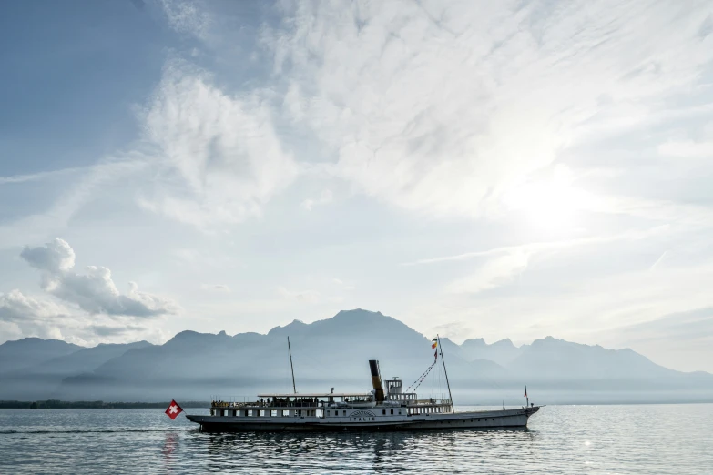 a boat floating on top of water under cloudy skies