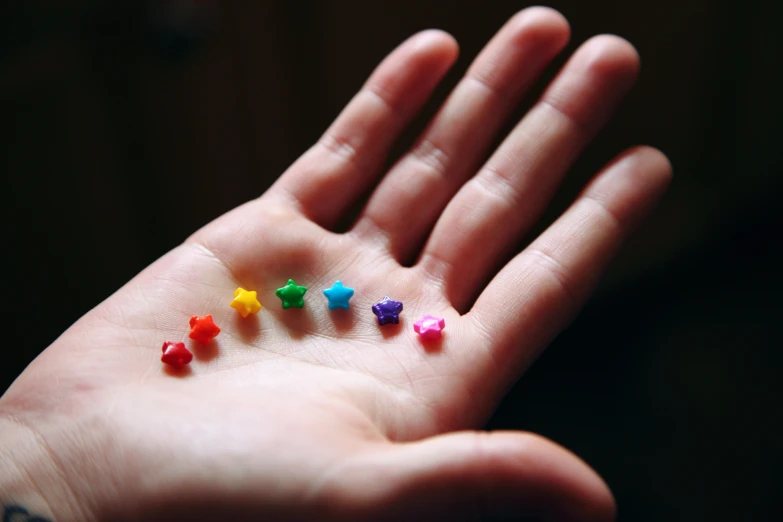 a person's hand with colorful studs on it