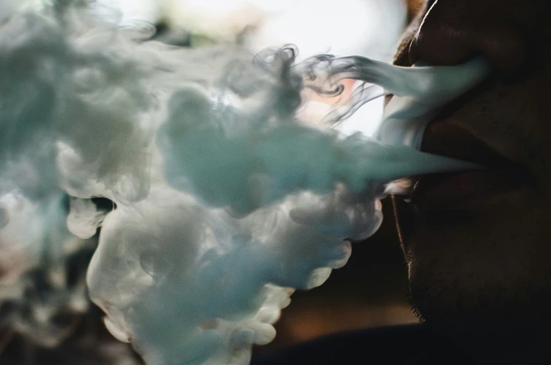 man smoking in dark smoke with flowers coming out of his mouth