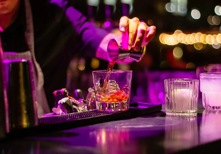 a man pours some liquor in a glass