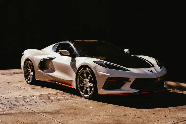 white sports car parked on asphalt near concrete