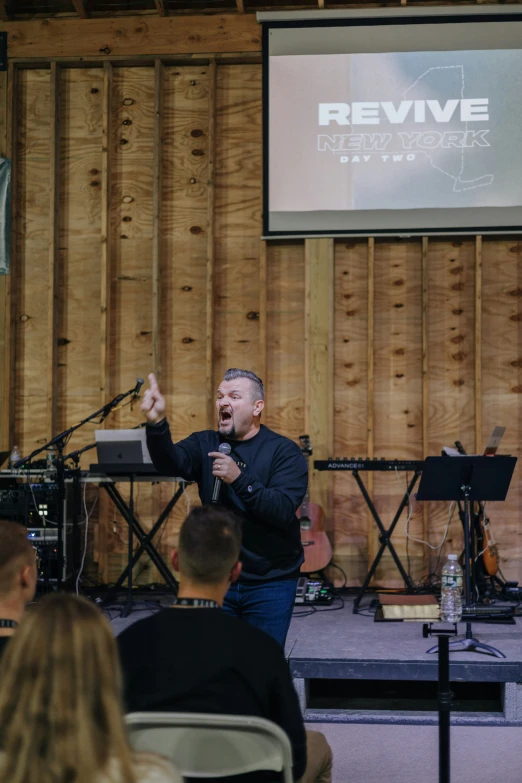 a man is singing into a microphone with two microphone stands