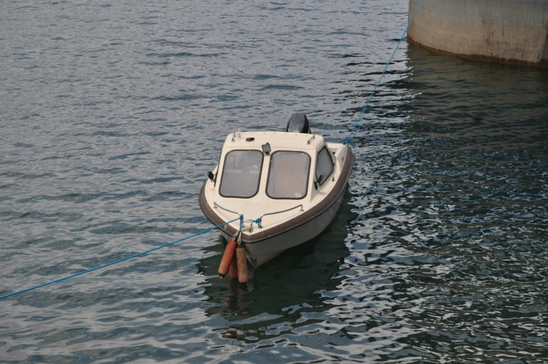 a small boat tied to a dock by a rope