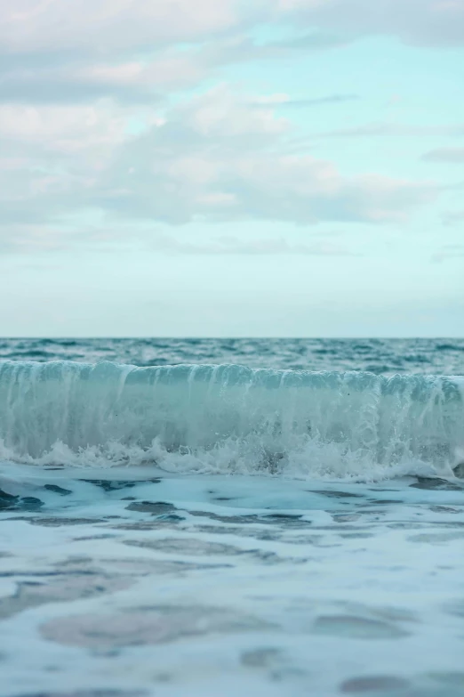 man riding surfboard through very large breaking waves