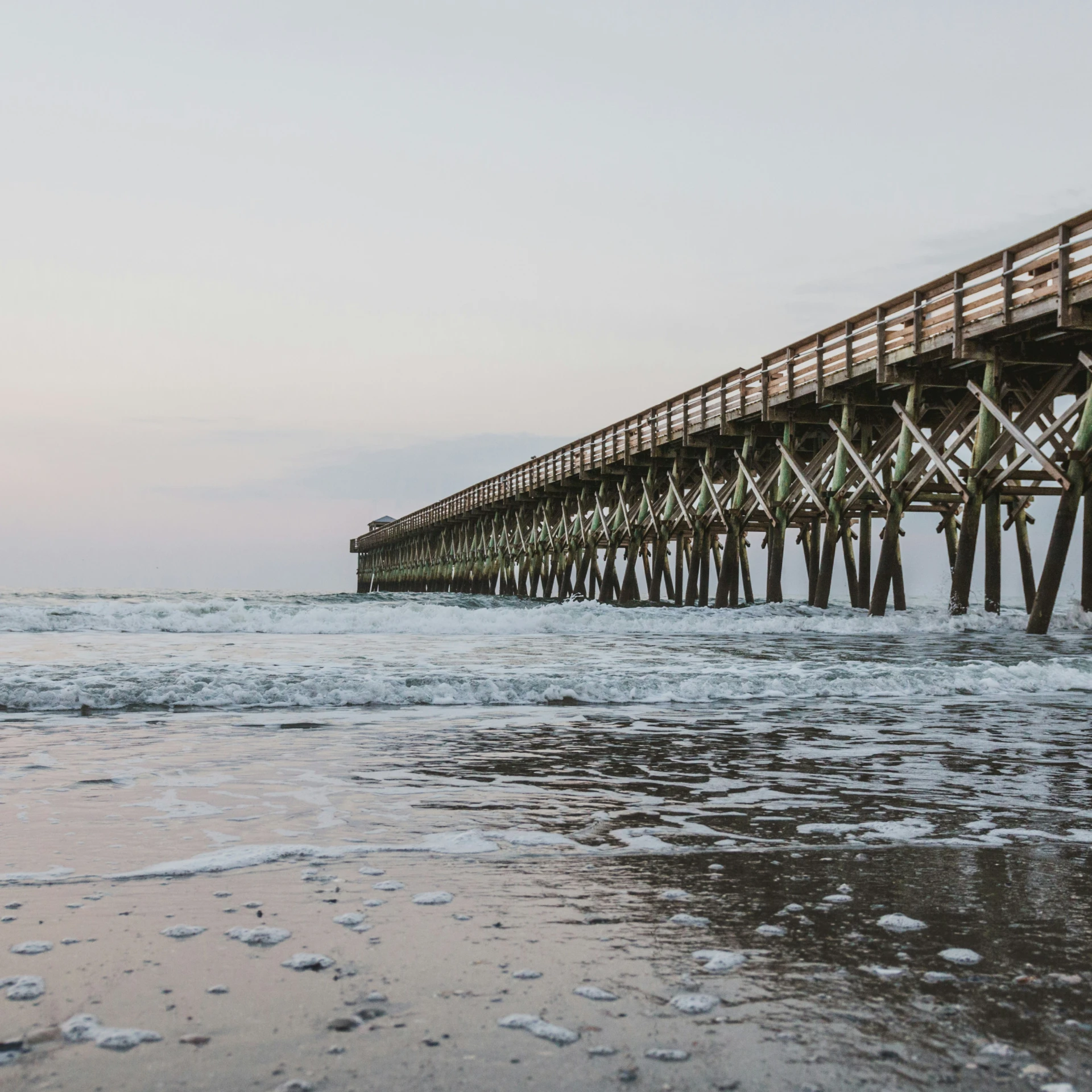 the large pier extends to provide water for the surfers to ride