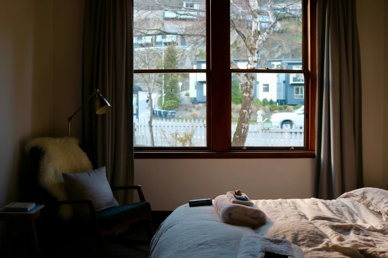 an unmade bed with a view of the snowy city