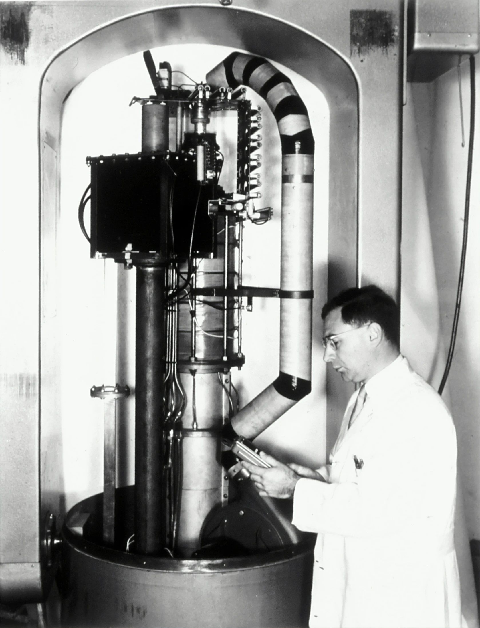 black and white po of man standing next to machine