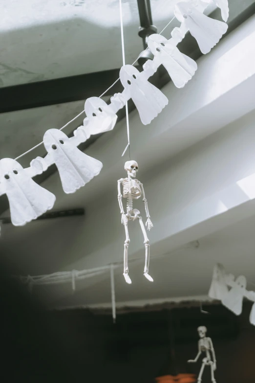 skeleton decorations hanging from a ceiling in a room