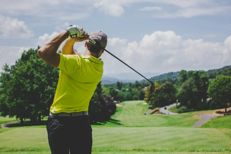 a man swinging a golf club at a green on the course