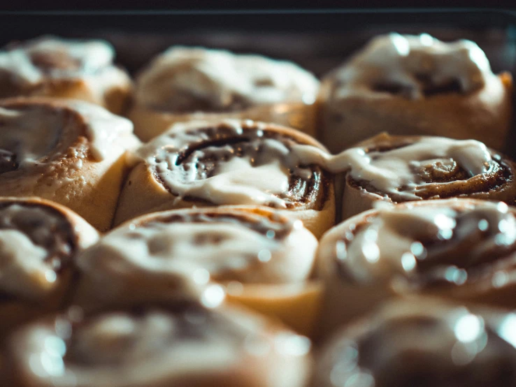 freshly baked cinnamon rolls in baking dish with frosting on top