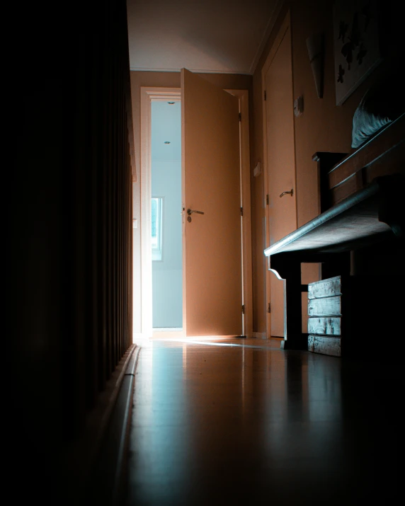 an open door at night next to a bench