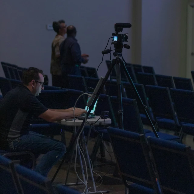 a man sitting in front of a camera in a room