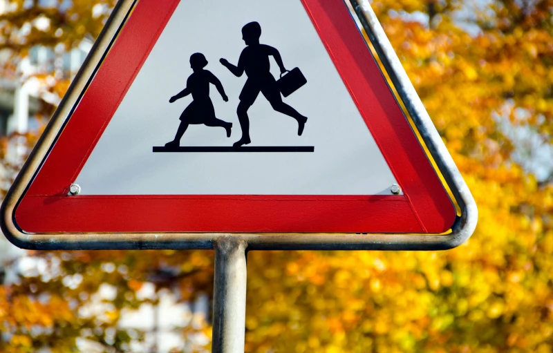 a red and white traffic sign with trees in the background