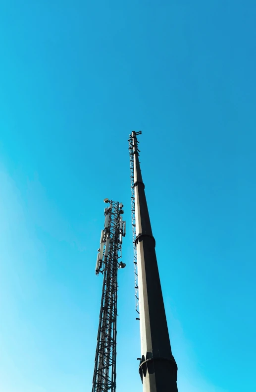 tall cell phone tower with antennas and blue sky