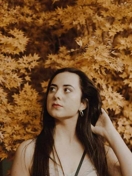 a woman that is standing near a tree