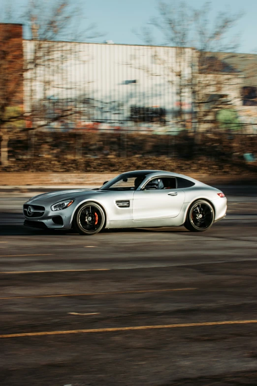 a silver sports car driving around a track