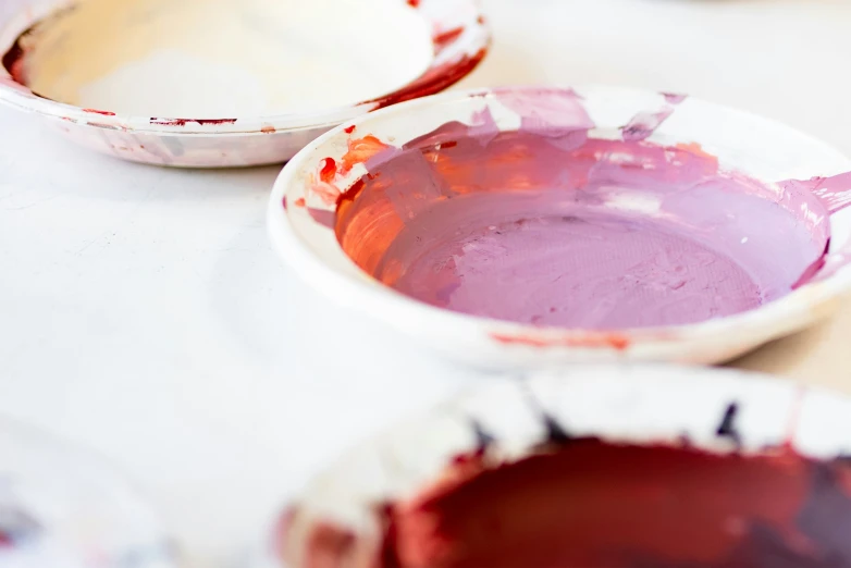 three bowls on a table with red paints