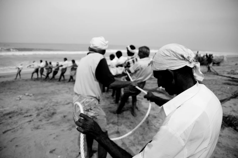 two men stand close together on a beach