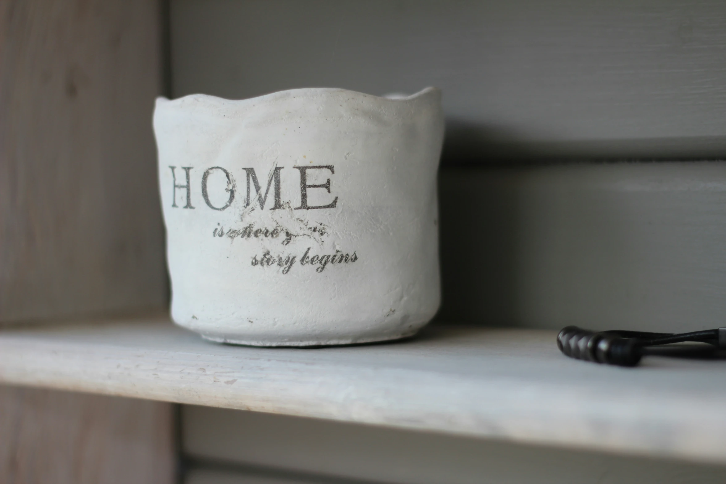 an old canister sitting on a shelf next to a brush