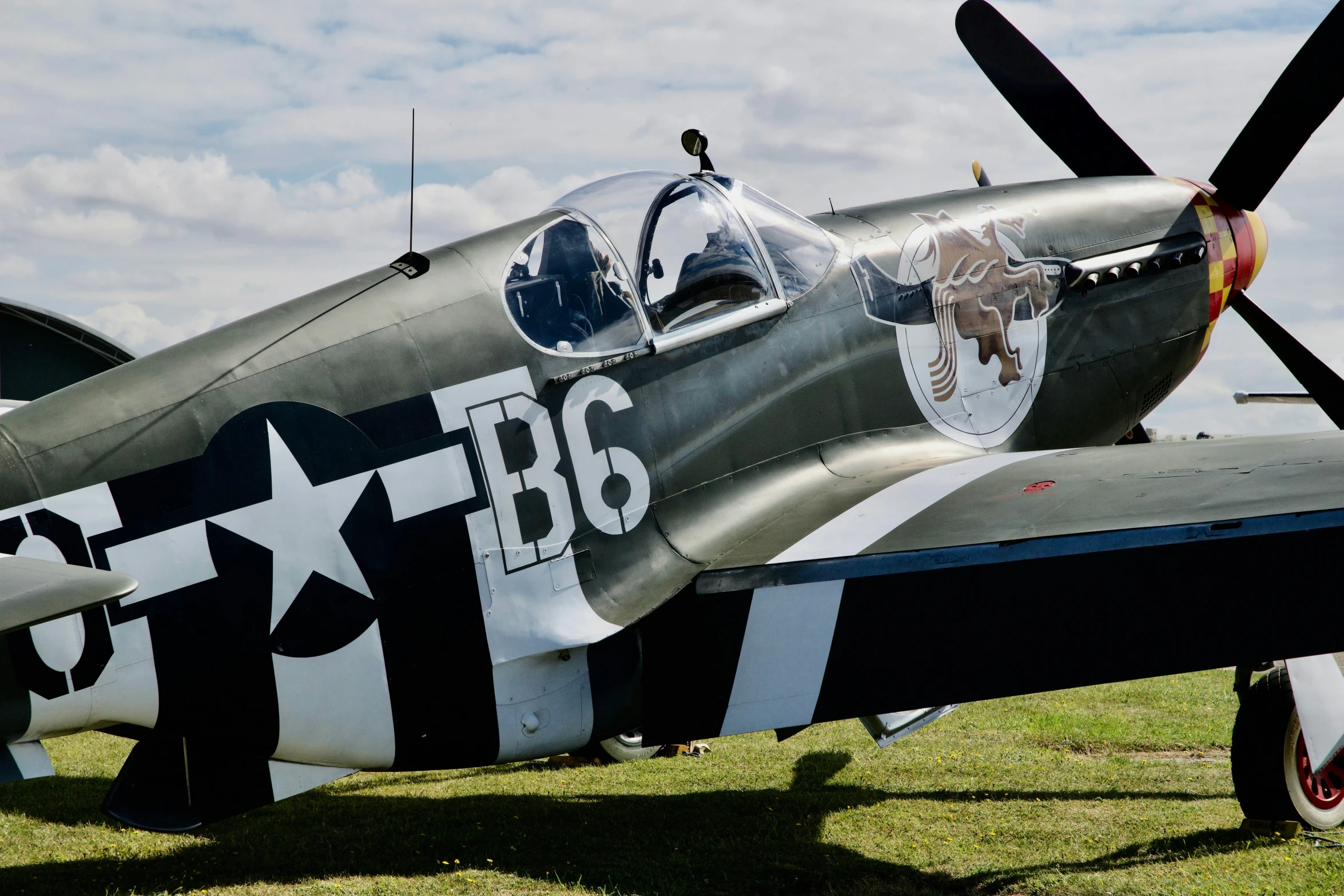 the fighter jet is sitting outside in a field