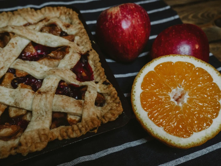 a piece of pie on a plate next to an orange