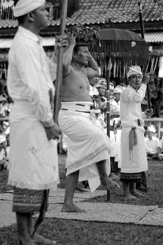 three men in traditional dress performing the traditional dance