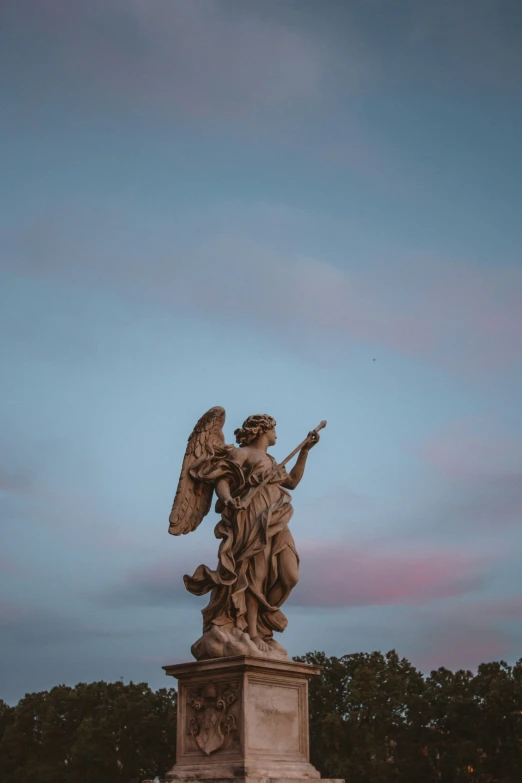 the statue on the ground has an angel on top