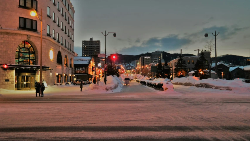 a road that has snow in front of a building