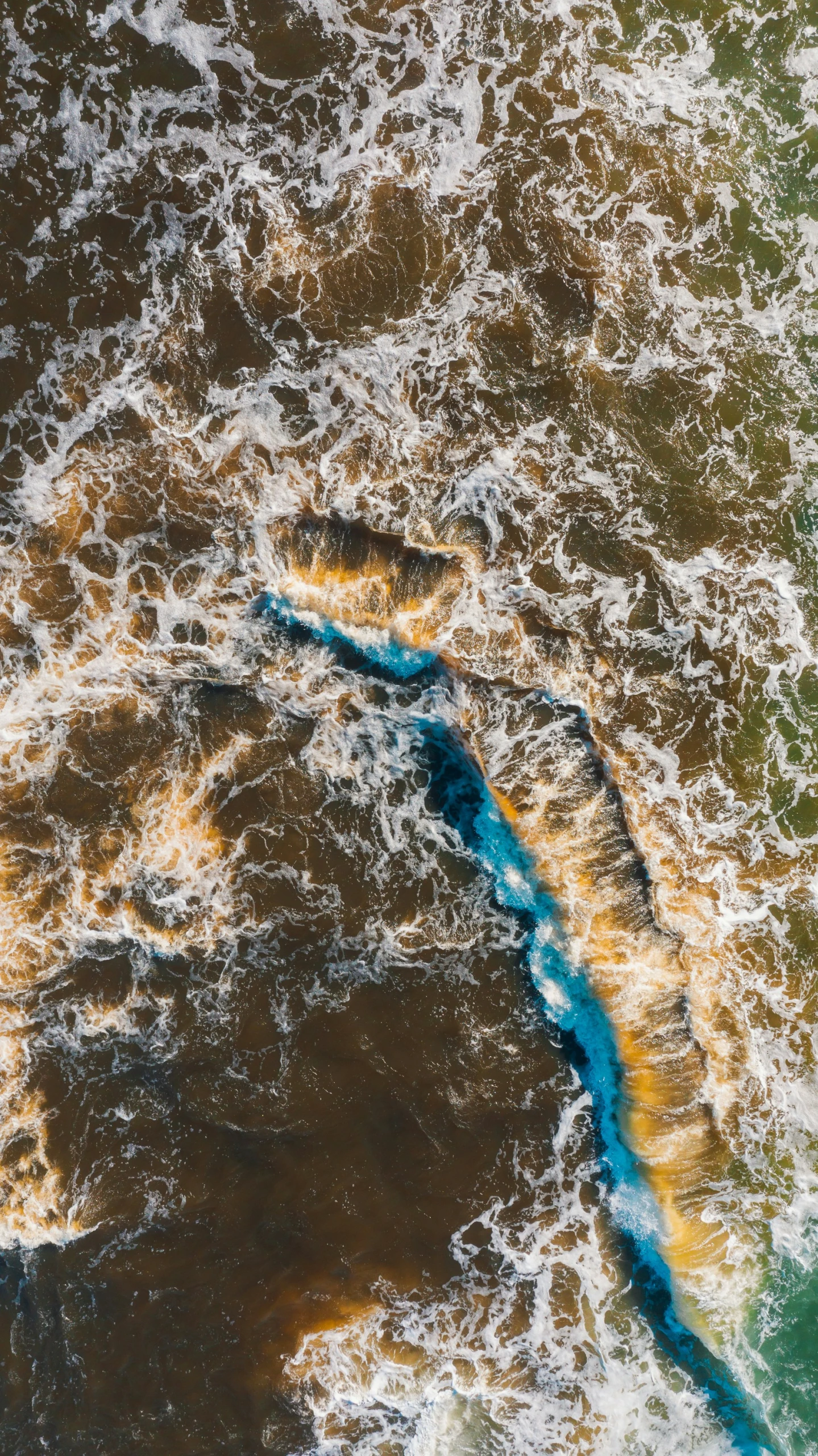 an aerial view of waves moving on to land