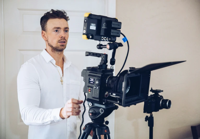 a man standing by a camera next to a door