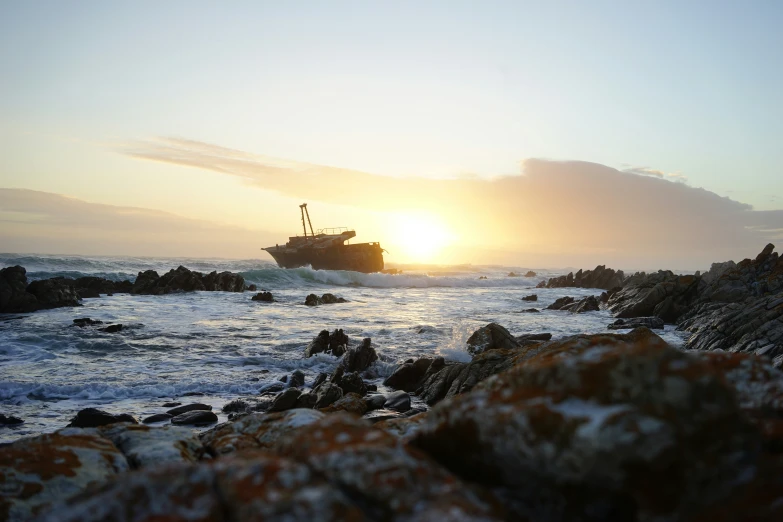 a boat is in the middle of the water at sunset