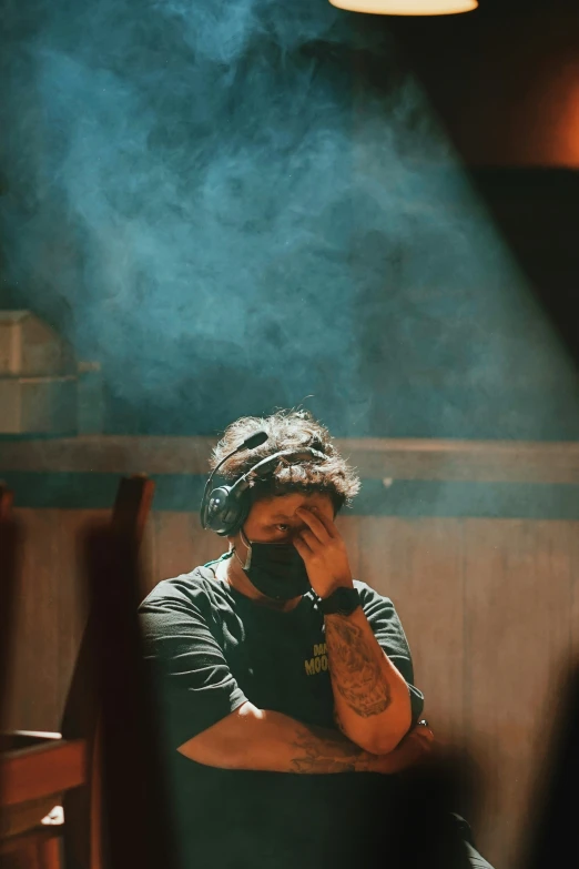 a man smoking a cigarette in a dark room