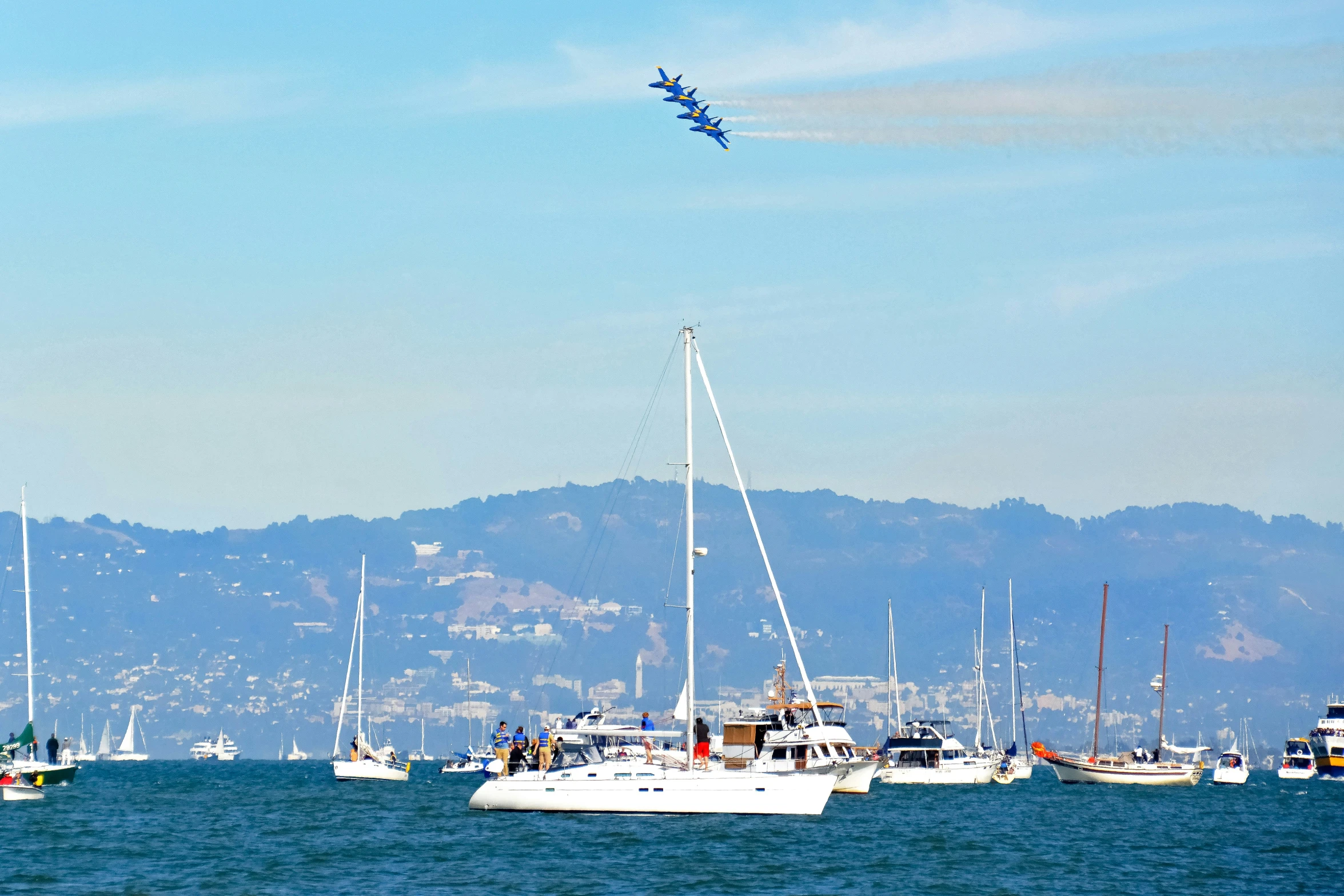 a small plane flying over boats in the water