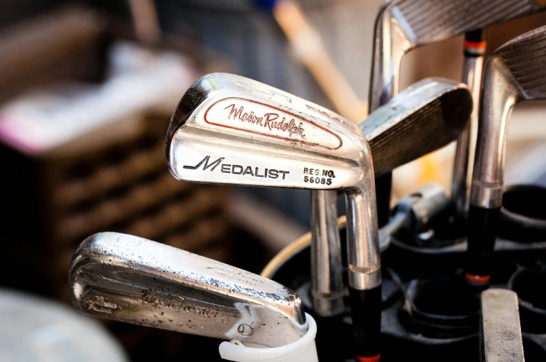 two irons are sitting in the holders of two golf clubs