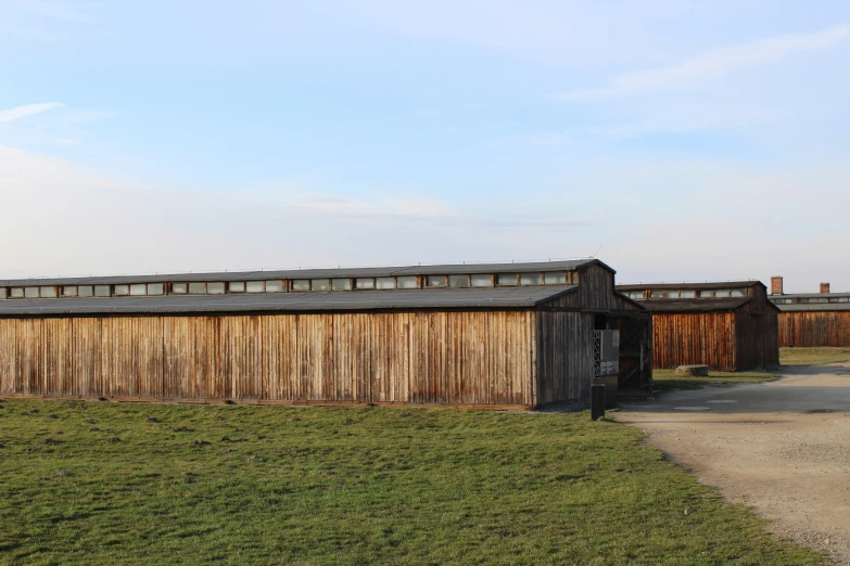 two buildings with windows and wooden fencing near grassy area