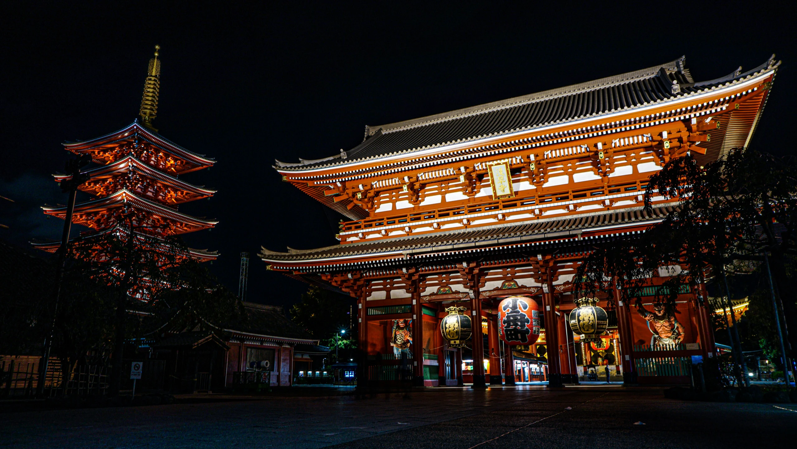 two lighted asian buildings are lit up at night